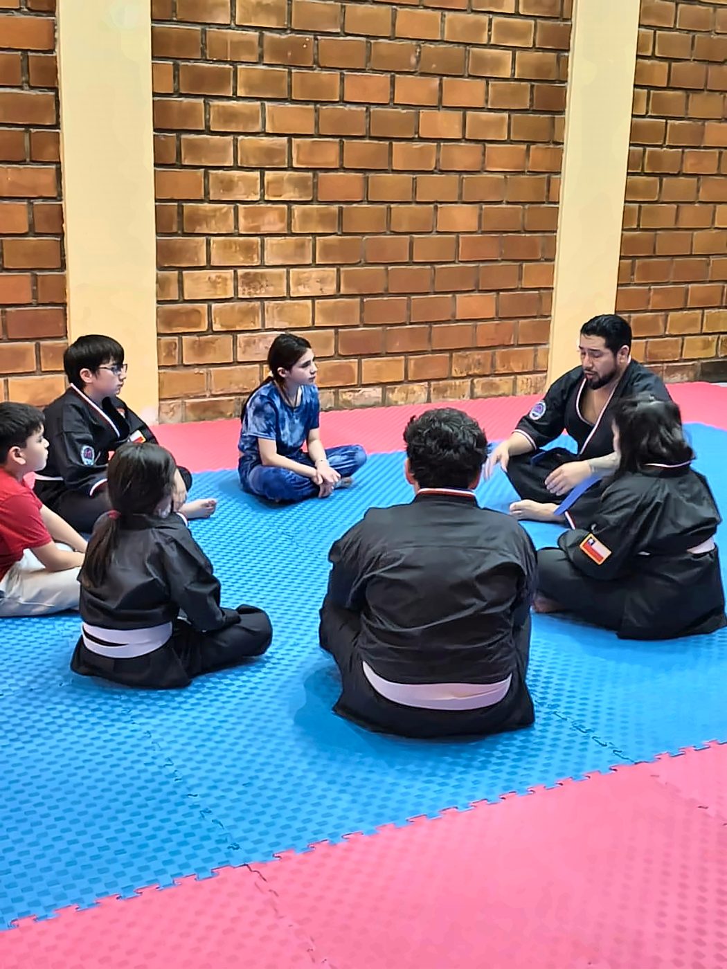 Sensei conversando con los alumnos sentados en círculo