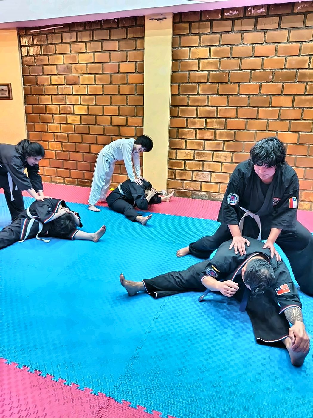 Alumnos elongando en parejas